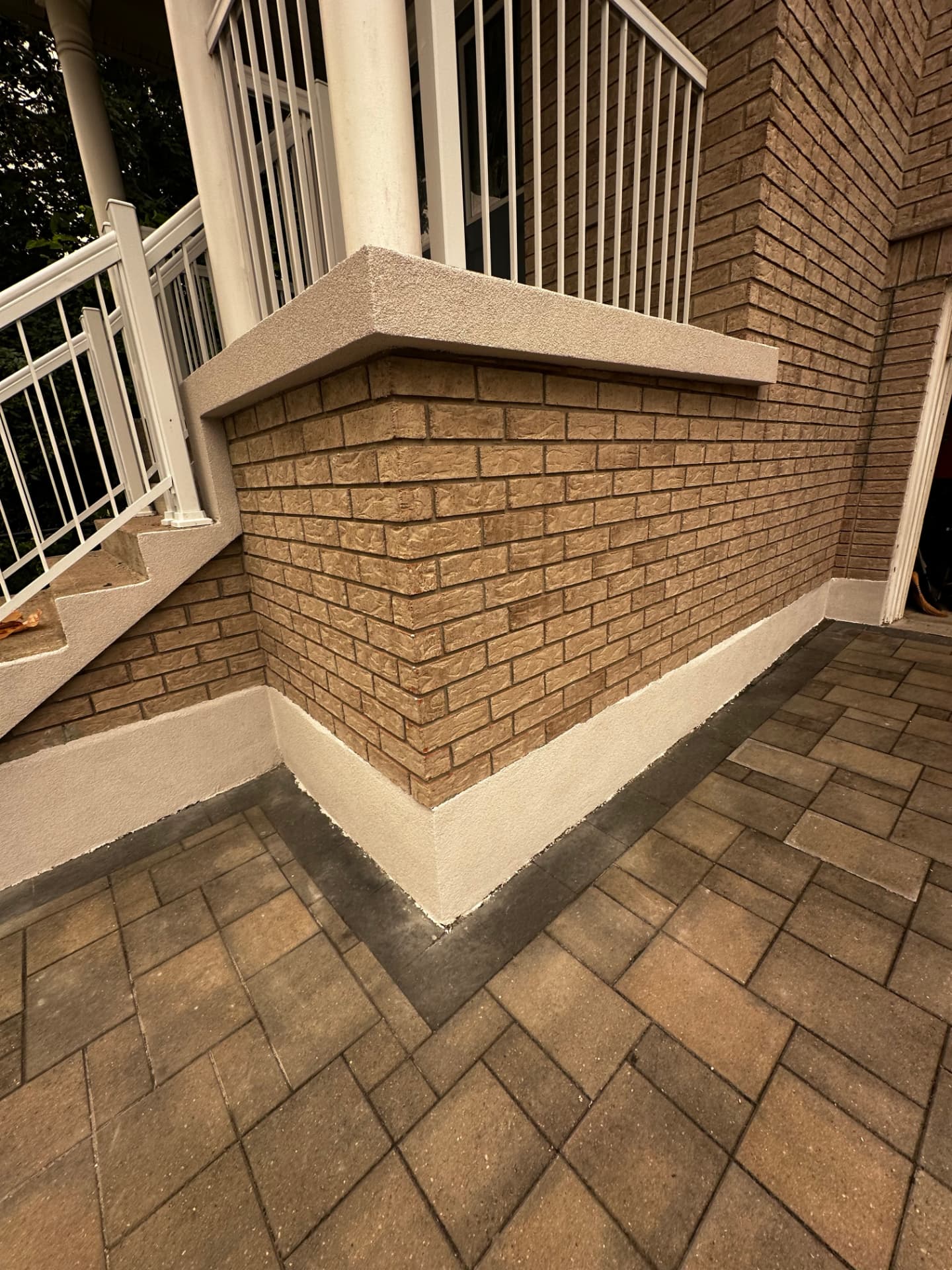 Porch wall and stair cheek capped in textured stucco